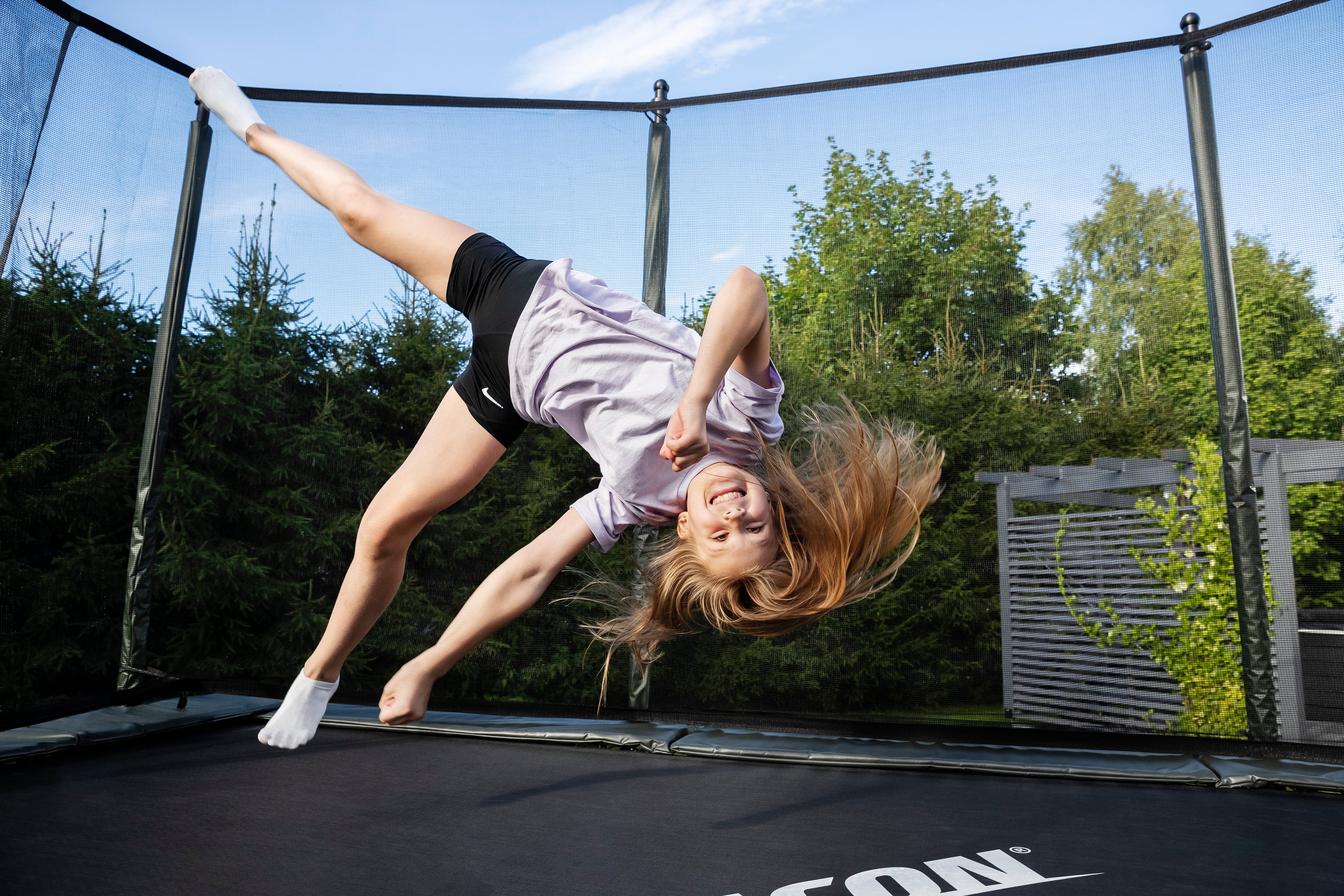 Tyttö tekee kärrynpyörän ACON trampoliinilla