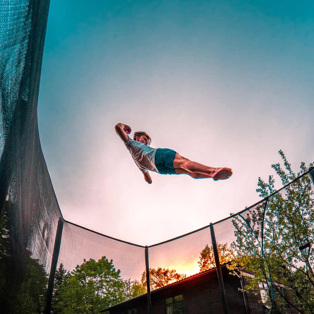 Poika hyppii ACON Air 16 HD trampoliinilla auringonlaskussa