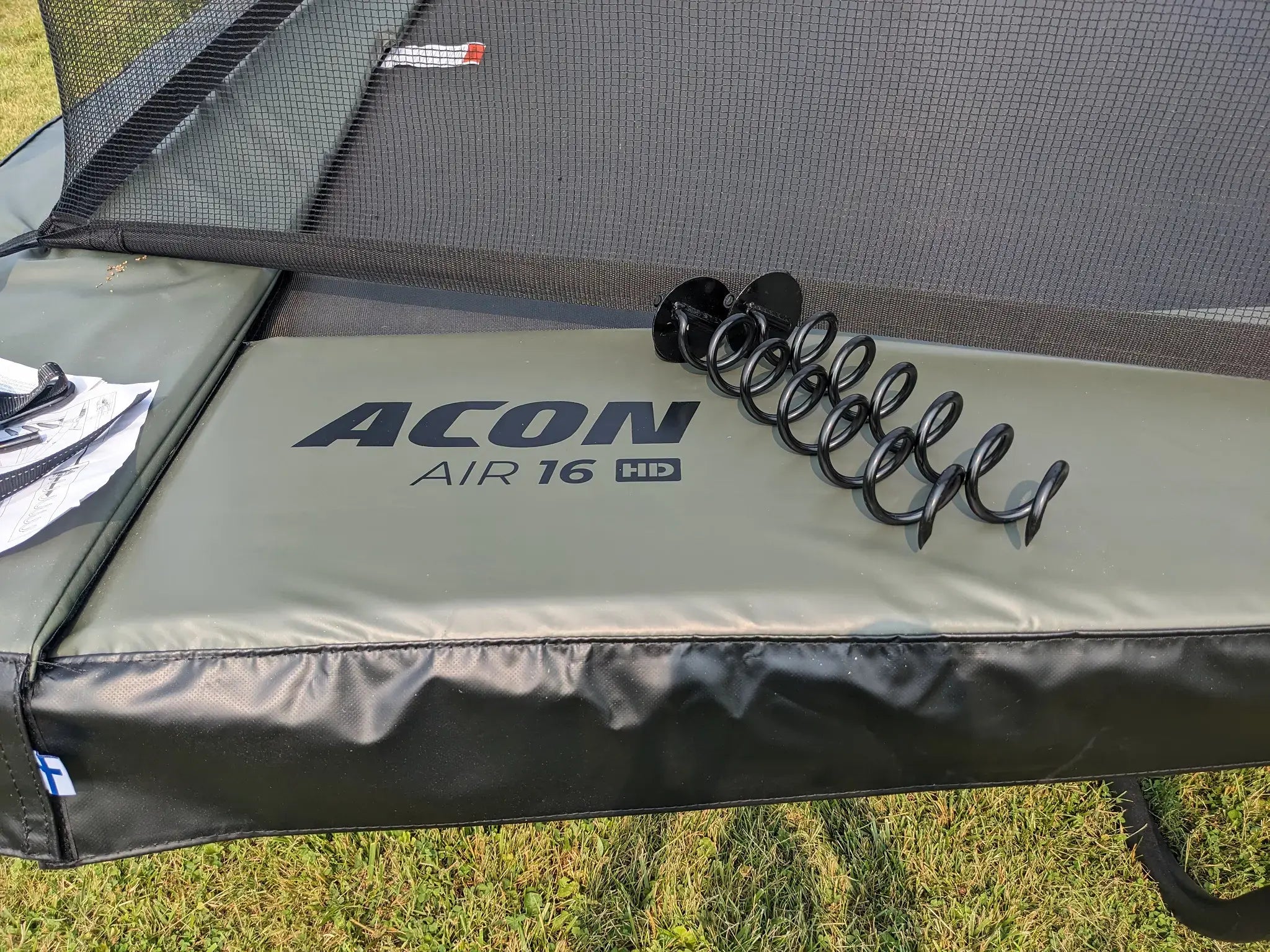 Acon Air 16 HD trampoliini, jonka reunalla trampoliinin ankkurit. 