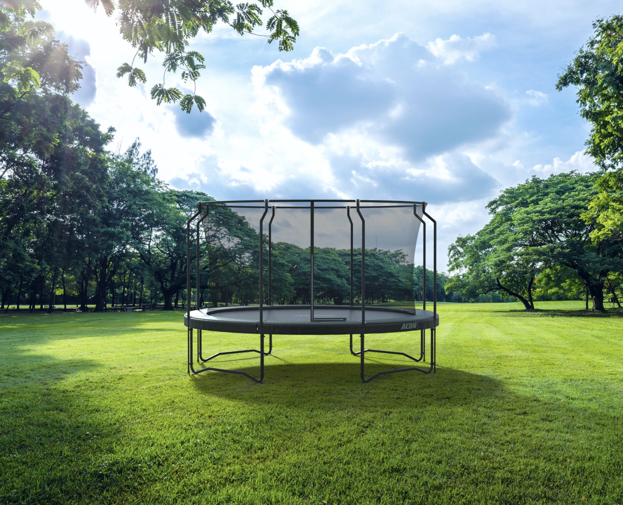 Acon trampoliini premium turvaverkolla takapihalla kesäisessä maisemassa nurmikolla.
