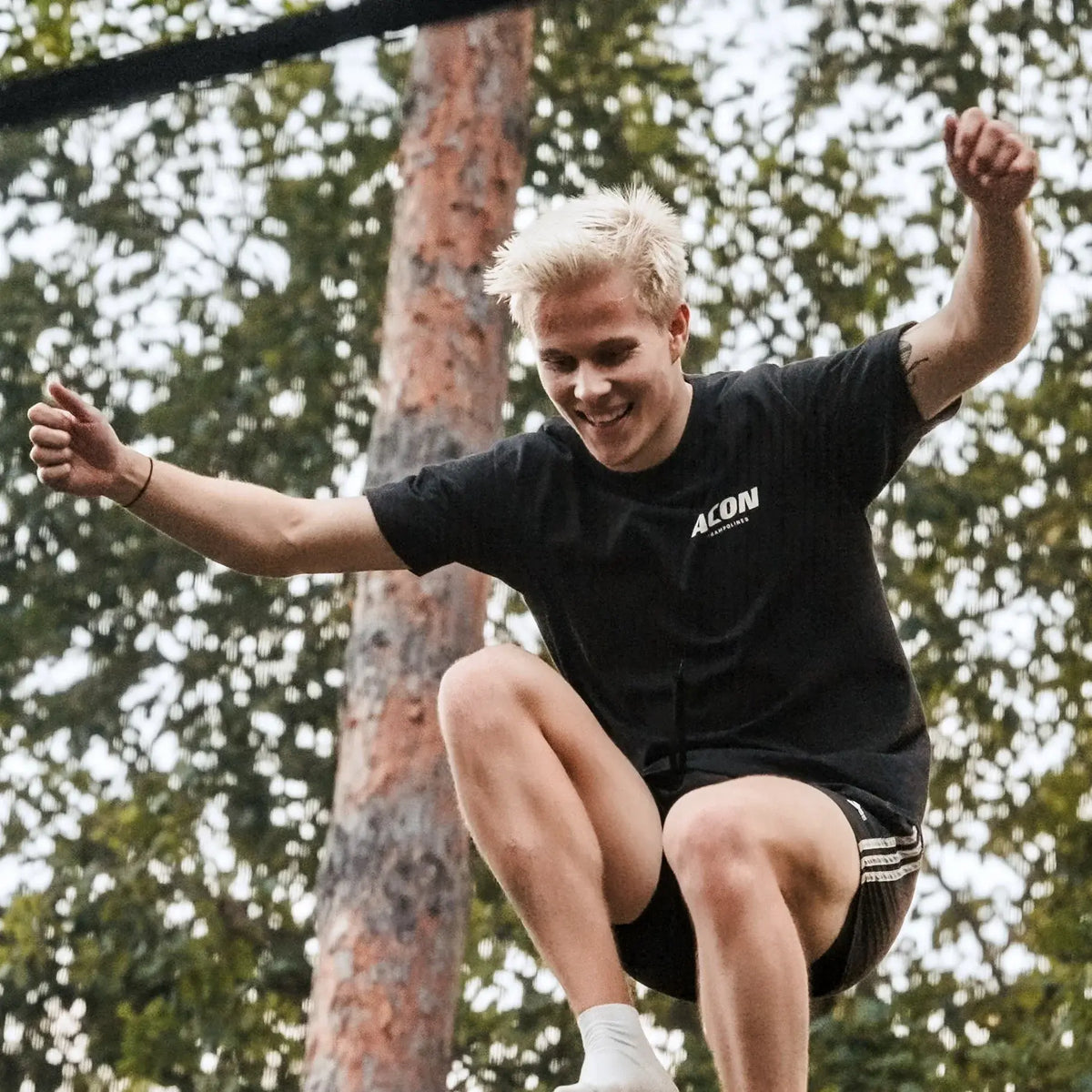Aleksi Sainio hyppää ilmaan trampoliinilla.