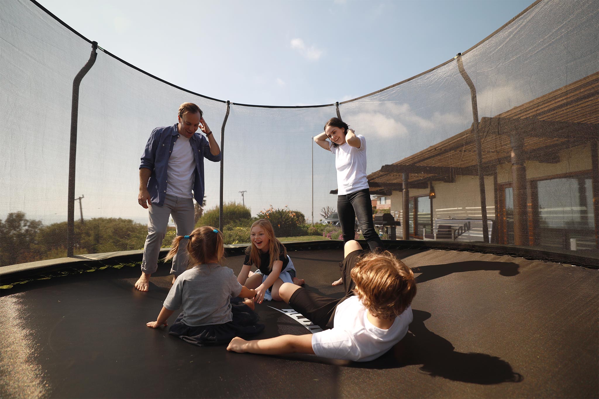 Koko perhe trampoliinilla