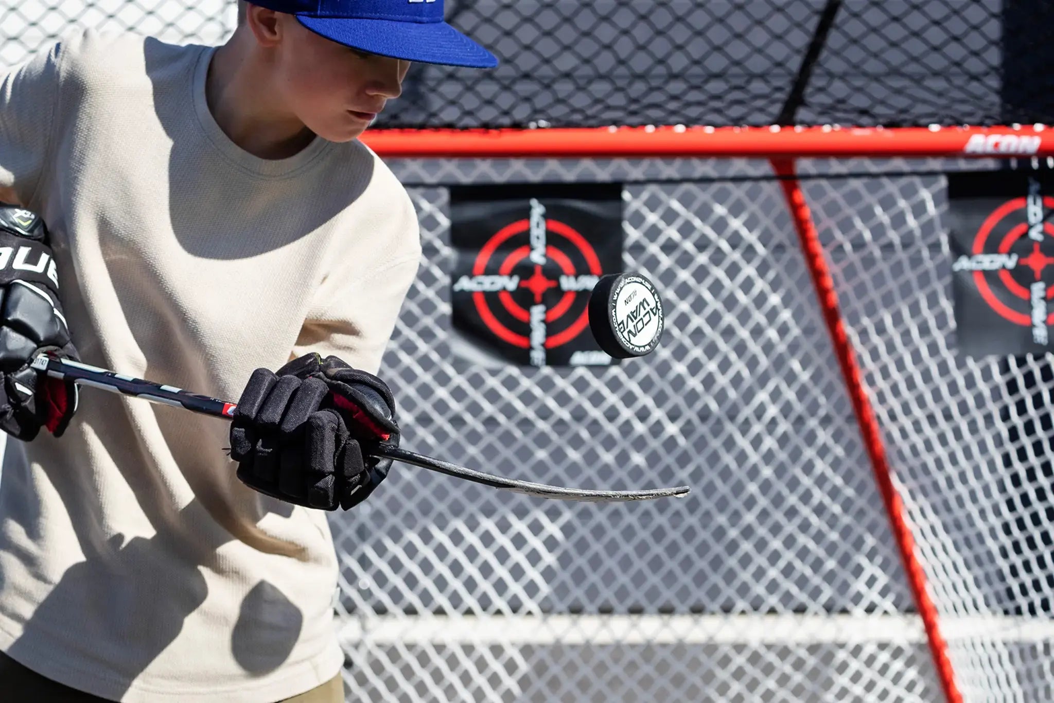 Lapsi jääkiekkovarusteissa harjoittelemassa kiekon käsittelyä mailalla.
