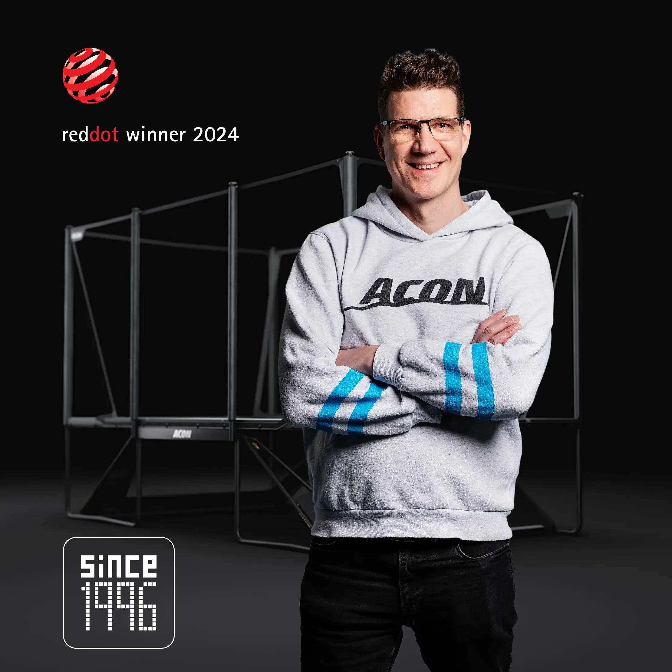 Aconin perustaja Tarmo Sallinen seisoo X-trampoliinin edessä. Kuvassa näkyvät Red Dot Awarded 2024 -merkki ja Since 1996 -merkintä.
