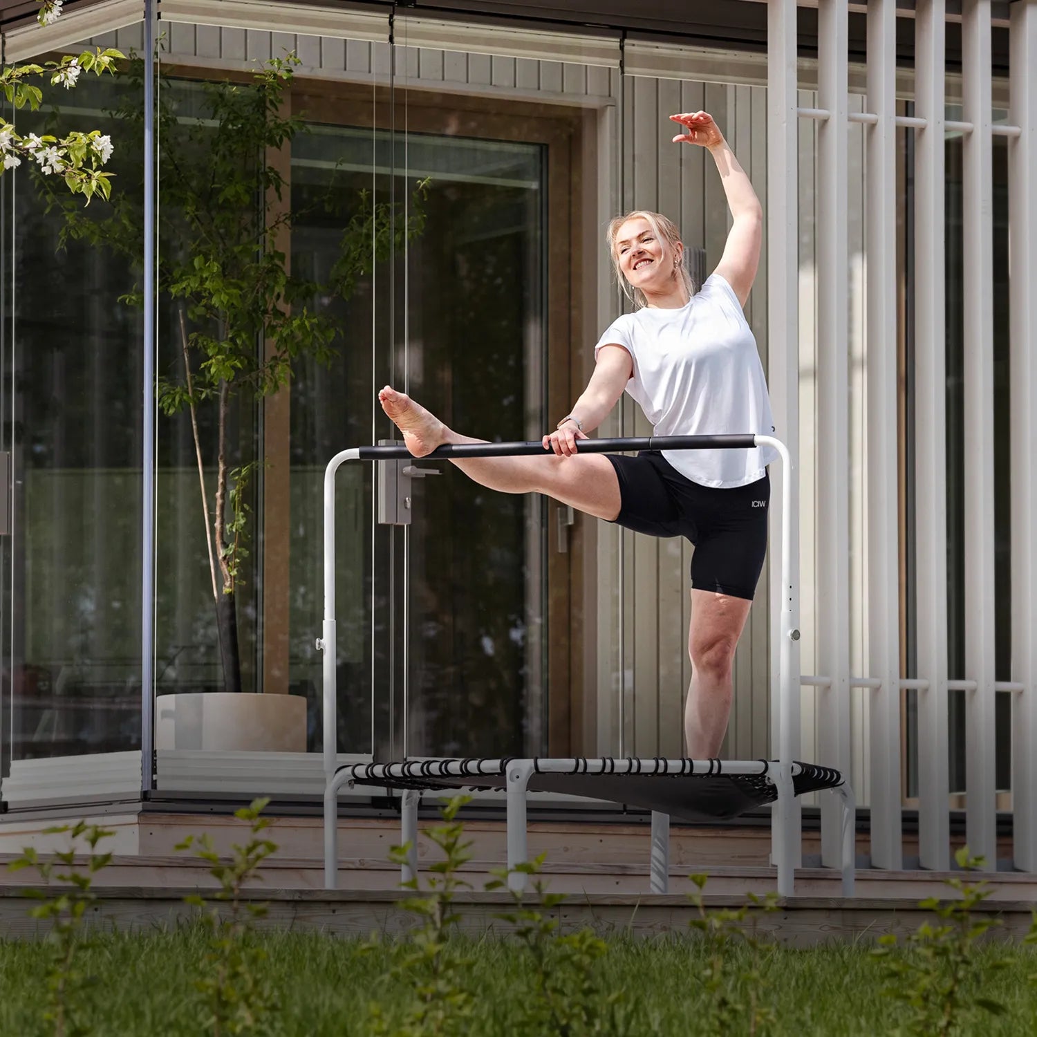 ACON Fit 1,12 m pyöreä trampoliini Balance-kahvatangolla käytössä venyttelyssä patiolla.
