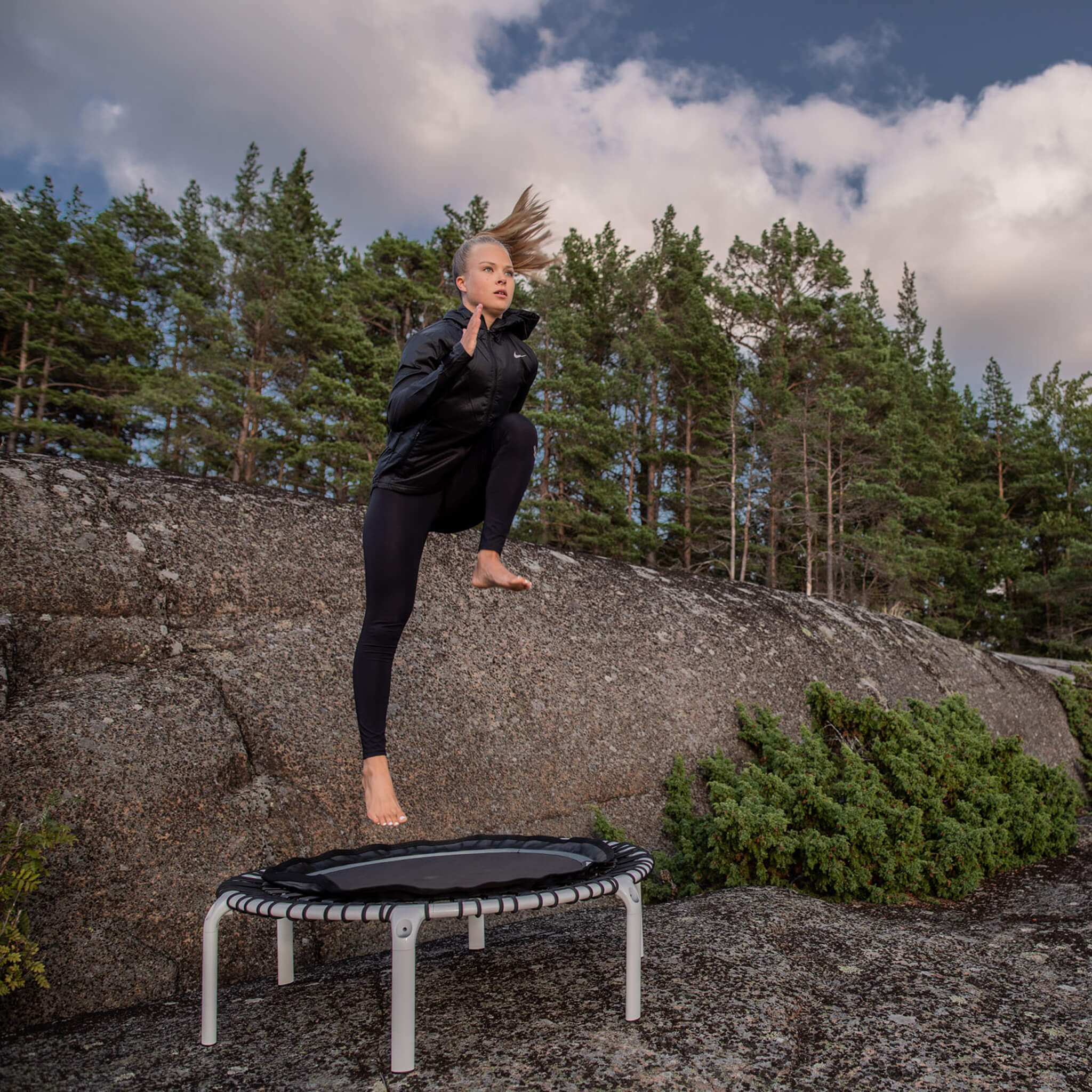 Nainen voimistelee Acon FIT-rebounderilla olohuoneessa.