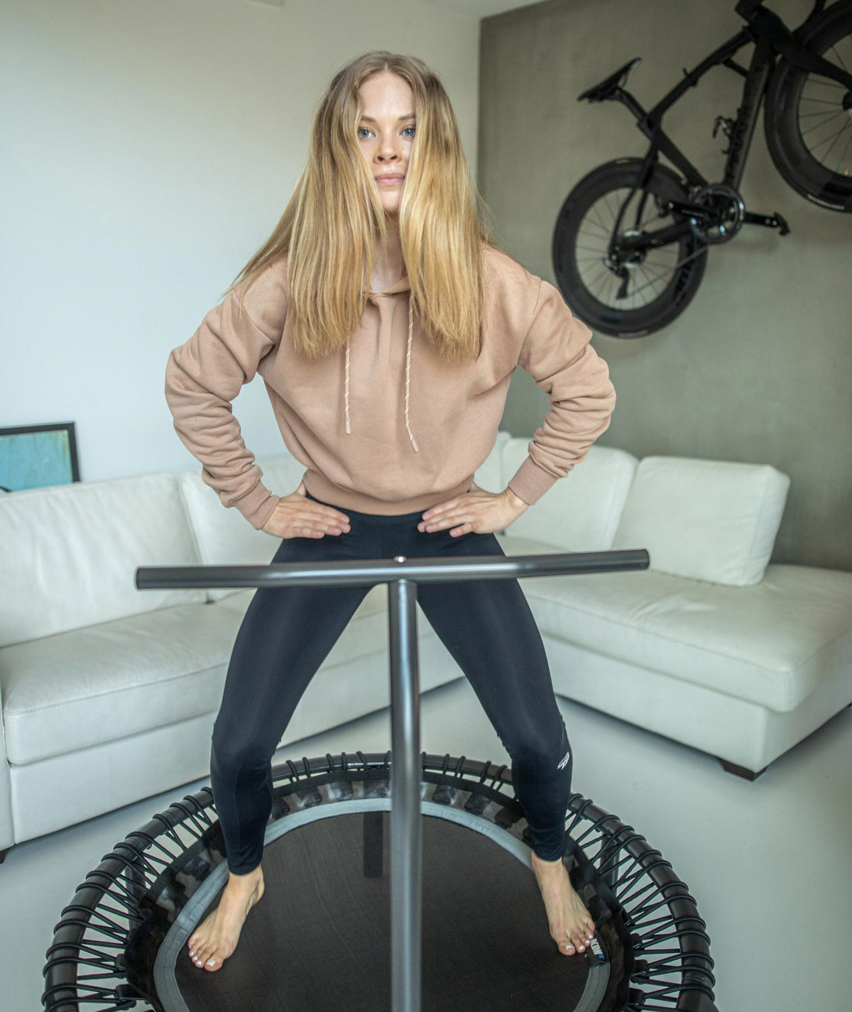 Nainen olohuoneessa seisoo fitness-trampoliinilla