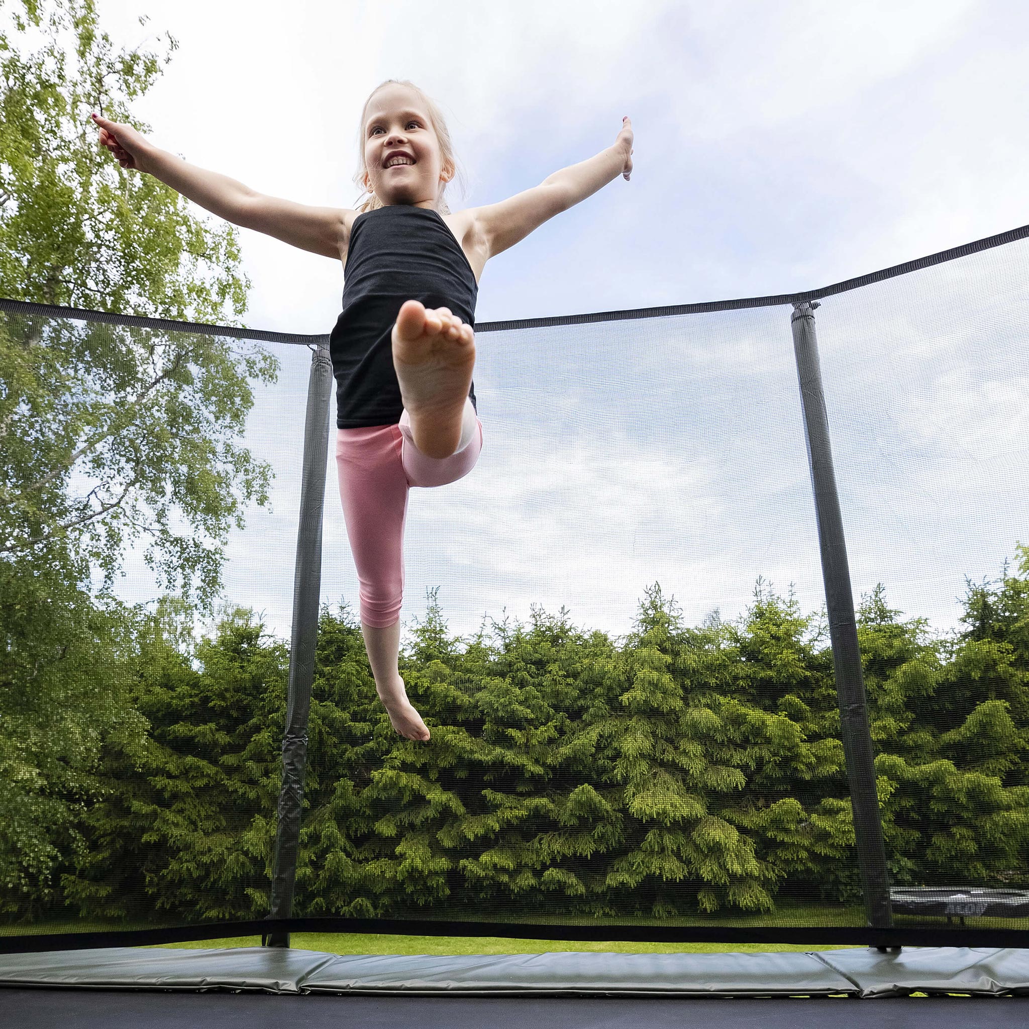 Tyttö hyppää Acon HD -trampoliinilla.